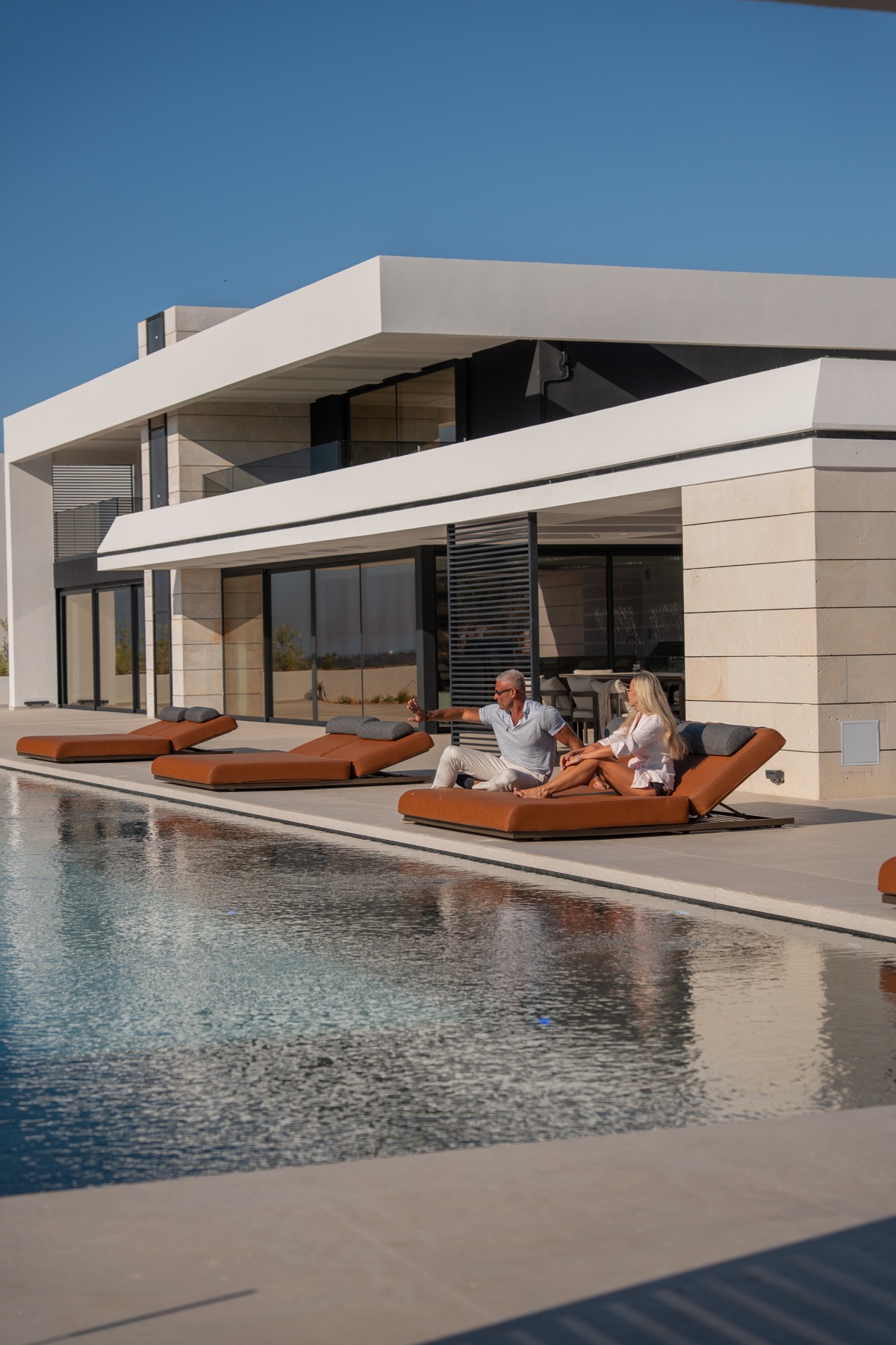Guests relaxing together beside the infinity pool