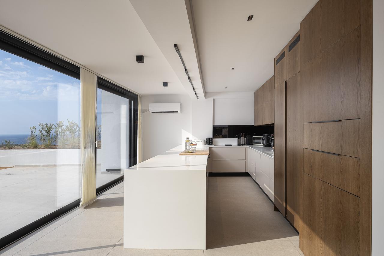 State-of-the-art kitchen with island and full-height glass facing the sea