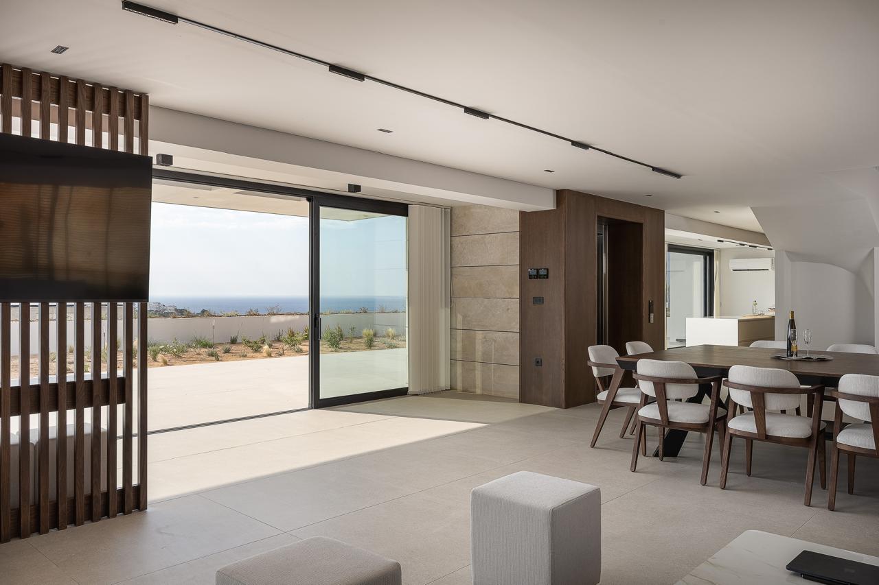 Living room and dining table opening to the terrace and the sea
