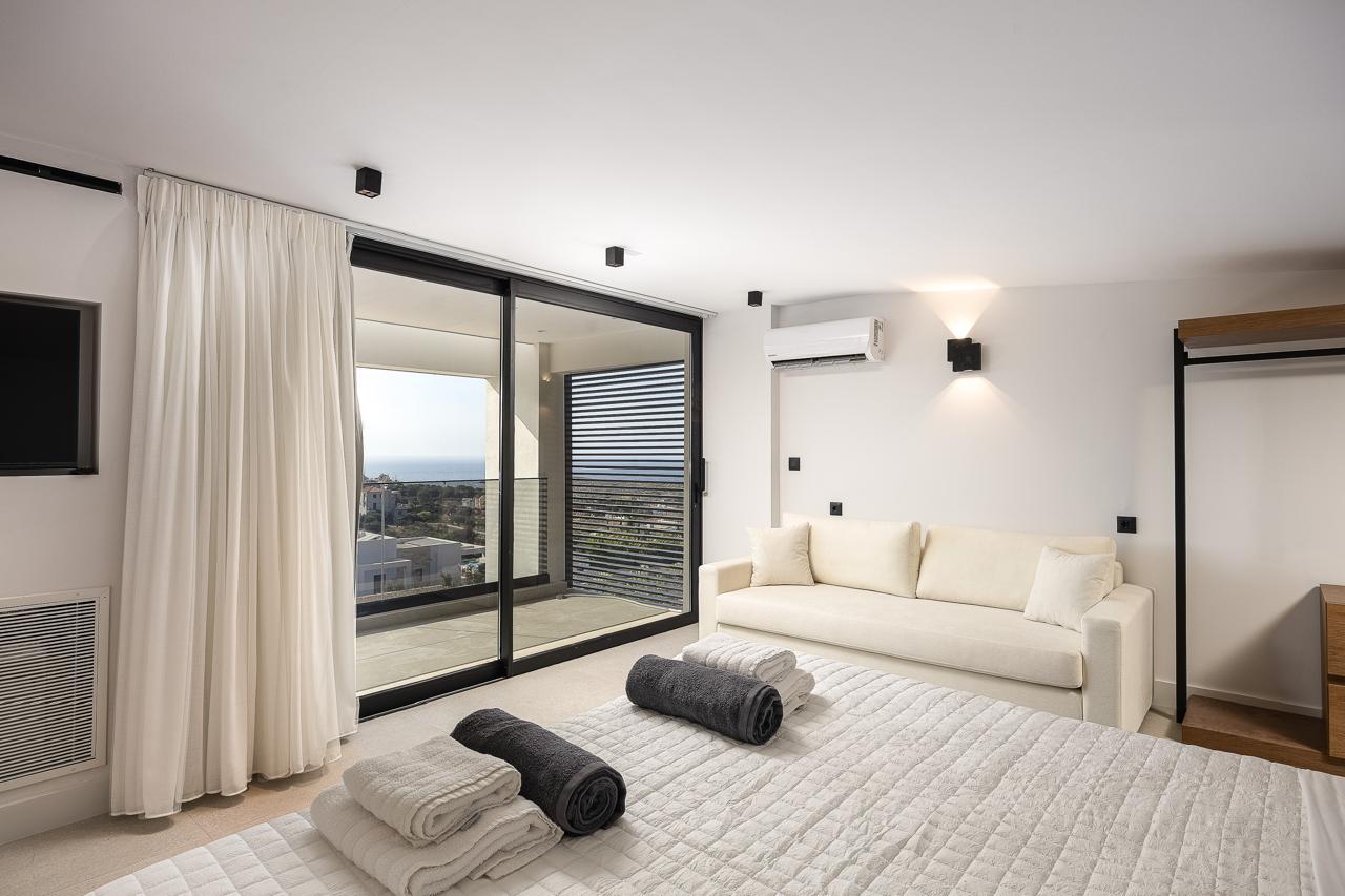The second primary suite with sofa and balcony doors