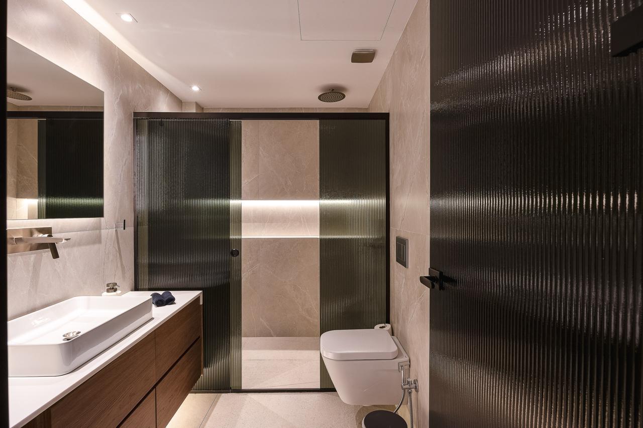 Stone bathroom with fluted glass and rain shower